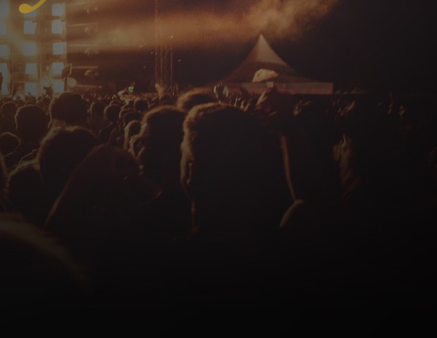 A festival crowd in front of a lit stage